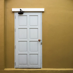 Abstract white door with yellow wall background