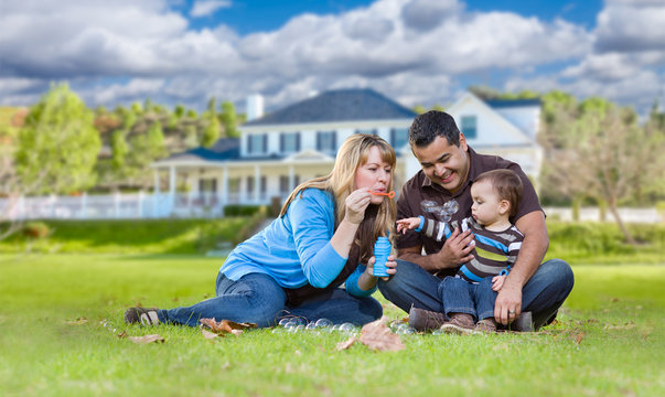 Happy Mixed Race Ethnic Family Playing with Bubbles In Front Yard