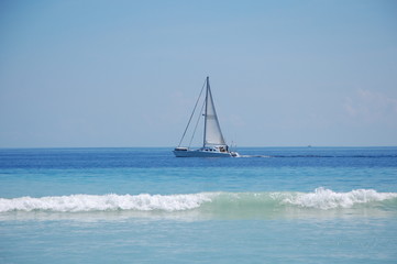 Obraz premium Beautiful lonely yacht with white sails in the ocean