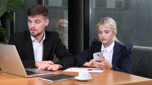 Two office workers reconcile their data sitting in the cafe