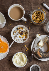 Breakfast set - yogurt, pumpkin granola, bagel, butter on a wooden table.  Top view. Flat lay