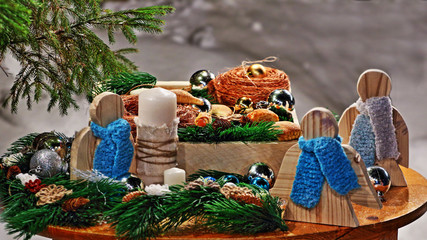 Christmassy still-life with lots of toys on a wooden board, on a background of snow and fir