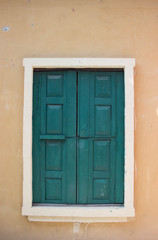 Obraz na płótnie Canvas Ancient green wood window on orange tone wall