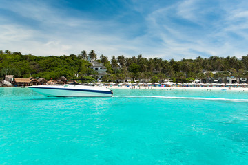 A yacht under the blue sky against a tropical beach