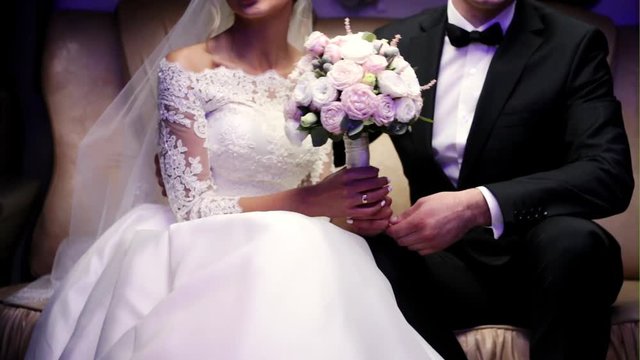 Bride and groom sitting happily in limo on wedding-day.
