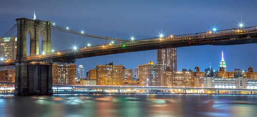 Panoramic view of Brooklyn Bridge at night with lights, New York