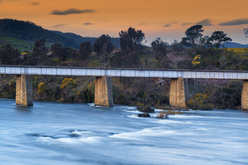 Country bridge and river in Tasmania, Australia at dusk.