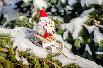 Christmas background with a snowman sitting on a sled 