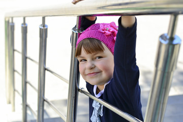 beautiful little girl goes to the bottom of the stairs holding o