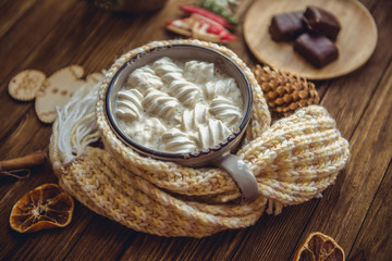 Hot cocoa with marshmallows spices on the old wooden boards.