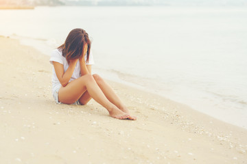 Fototapeta na wymiar Lonely girl crying on the beach
