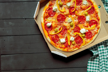 Fresh tasty pizza on wooden background