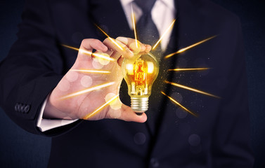 business person holding an electric light bulb