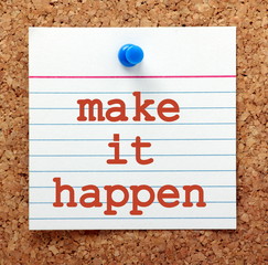 The words Make It Happen in red text on a note card pinned to a cork notice board as a reminder and for motivation