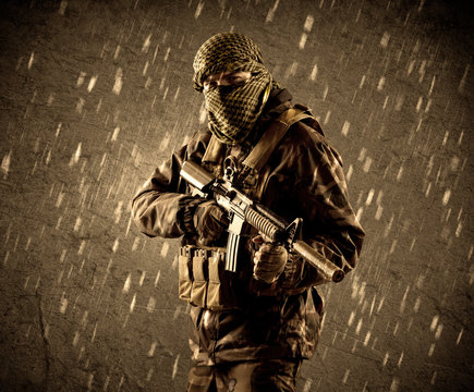 Dangerous heavily armed terrorist soldier with mask on grungy ra