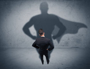 Successful businessman with superhero shadow
