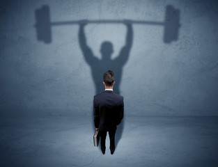Obraz premium Businessman with weight lifting shadow