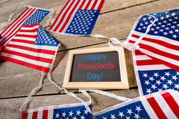 the text happy presidents day written in a chalkboard and a flag of the United States