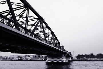 Black and white bridge across a Chao Phraya river 

