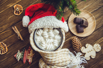 Hot cocoa with marshmallows spices on the old wooden boards.