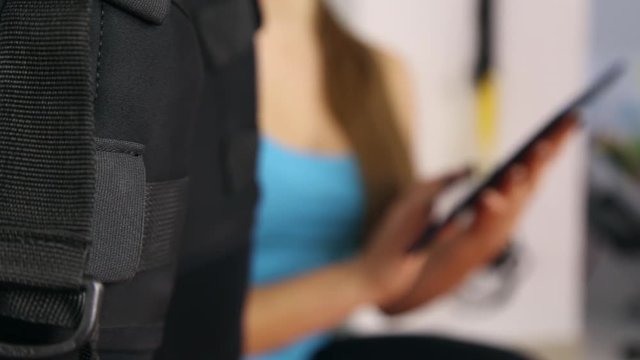 Muscle athlete vibrate, personal ems training in the gym with a trainer, which uses tablet
