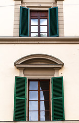 Fototapeta premium two windows with green blinds in urban house