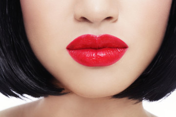 Close-up shot of beautiful woman's red lips over white background