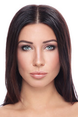 Obraz premium Portrait of young beautiful tanned woman with long straight hair and stylish make-up over white background