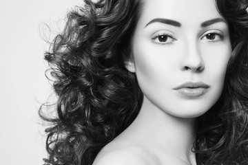 Black and white portrait of young beautiful woman with long curly hair