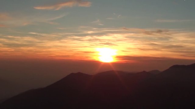 Fiery sunset from mountain pick with thin glazes in the sky evening. Fall season. Orobie alps. The summit of Mount Rena. Bergamo Italy. 