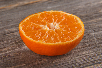 Half of mandarin on gray board/Close up of sliced mandarin