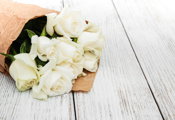 Fototapeta na wymiar White roses on a wooden table
