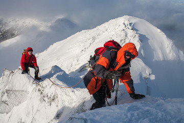 Naklejka premium Mountaineering. Teamwork in alpinism. Traverse of mountain.