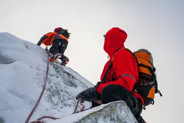 Fototapeten Mountaineering. Teamwork in alpinism.  Traverse of mountain. © Aleks Kend