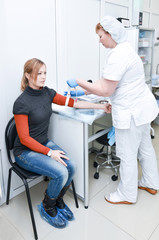 Nurse takes a blood sample from a female patient for testing
