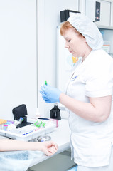 Nurse takes a blood sample from a female patient for testing
