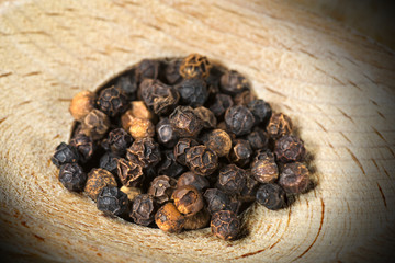 Peppercorns on a wooden background (wooden spoon) 