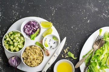 Ingredients for a light salad of quinoa, cucumber, cheese and sweet red onion with butter  lettuce on   gray background. Top view
