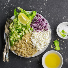 Ingredients for a light salad of quinoa, cucumber, cheese and sweet red onion with butter  lettuce on   gray background. Top view