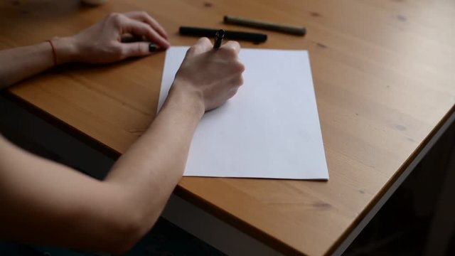 Hands writing on the paper.