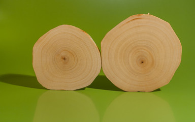 Two polished and oiled alder saw cuts on green background.