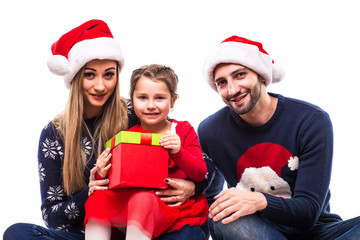 Young daughter get Christmas gift near mother and father on white background.