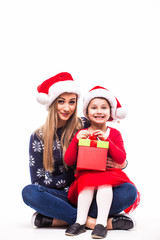 Young mother and her daughter with Christmas gift on white background