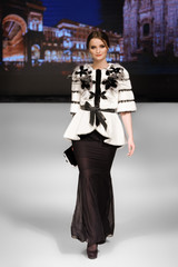 Fashion model walks on runway in fur coat
