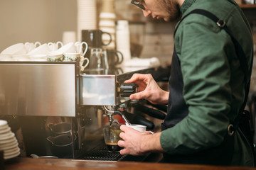 Man hands pours drink from a coffee machine.