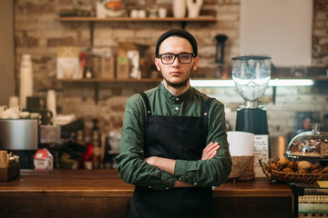 Barman standing against bar counter