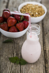 Smoothies and ripe strawberry on a wooden table. Milk drink with