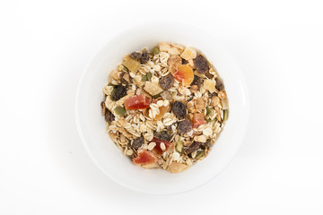 Bowl of muesli with dry fruits, on white background.