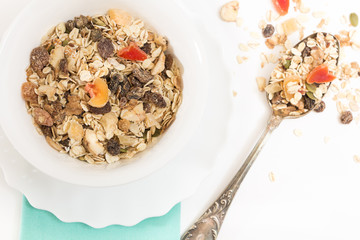 Bowl of muesli with dry fruits, on white background.