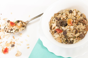 Bowl of muesli with dry fruits, on white background.